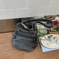Gros plan du sac bandoulière en jean vintage avec zips et détails de franges - Noir