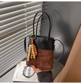 Dettaglio della borsa a secchiello vintage con camoscio trapuntato e nappe in legno - Con Ciondolo / Marrone