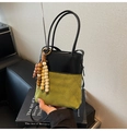 Dettaglio della borsa a secchiello bicolore con pelle scamosciata e perline di legno - Con Ciondolo / Verde