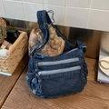 Sac bandoulière en denim bleu foncé avec plusieurs zips sur une table en bois - Bleu foncé