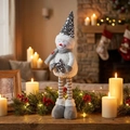 Détail d'un bonhomme de neige à paillettes avec jambes extensibles dans un décor de Noël - Petit Bonhomme de Neige à Paillettes Grises