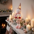 Détail d'un bonhomme de neige de Noël à LED avec paillettes près de la cheminée - Petit Bonhomme de Neige à Paillettes Roses