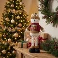 Detail showing a plush Christmas cat doll in festive plaid outfit on a wooden surface - Telescopic Cat (ML-Q777)