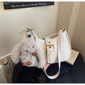 Close-up of white hobo bag with gold buckle detail and a cute grey bunny plush charm - Beige With Charm