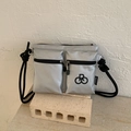 Detail van zilveren nylon crossbodytas met twee voorzakken en zwart touw schouderband - Zilver