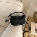 Detail of black lychee leather crossbody bag with silver twist lock and beaded charm pendant - With Charm / Black