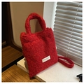 Sac cabas en peluche rouge avec paillettes et écusson sur un rebord de fenêtre - Rouge