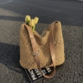 Beigefarbene Häkel-Tragetasche mit Blumenmuster und braunem Lederriemen auf Büchern - Khaki