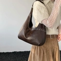 Détail du sac cabas marron foncé vintage avec œillets argentés et texture en cuir lisse - Marron