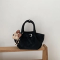 Detail of a black suede bucket bag featuring a cute plush bear charm with polka dot bow - Black with Pendant