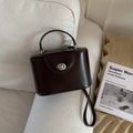 Détail d'un sac boîte marron foncé avec fermoir rotatif argenté et finition lisse - Brun Sans Pendentif