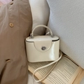 Détail du petit sac vanity crème en cuir avec son fermoir rotatif en métal argenté - Blanc Sans Pendentif