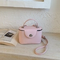 Vue détaillée du sac rose avec fermoir rotatif argenté et texture en cuir lisse - Rose Sans Pendentif