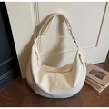 Detail view of large cream hobo bag with glossy finish and vertical stitching on wood floor - Off White