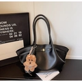 Detail of black PU leather tote bag featuring golden buckle and cute plush dog charm - With Charm / Black