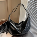 Glossy black large capacity crescent hobo bag with a zipper in a workspace setting - Black