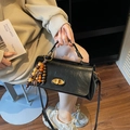 Retro black leather crossbody bag with gold buckle and wooden beaded tassel accessory - With Charm / Black