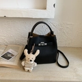 Elegant black lychee leather bucket bag with metal lock and cute plush charm pendant - Black With Pendant