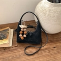 Détail du sac à main en daim noir avec surpiqûres blanches et pendentif à pompon décoratif - Avec Pendentif / Noir