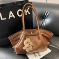 Braune Leder-Shopper-Tasche mit langen Henkeln und Plüsch-Hundeanhänger auf Schwarz - Mit Anhänger / Braun