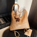 Große Retro-Tragetasche in Khaki aus Kunstleder mit Kreuznähten und Bärenanhänger - Khaki mit Anhänger