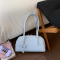 Detail of light blue leather bowling bag with star charm on dark wood floor - Blue