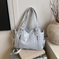Bolso tote grande azul claro con cremalleras dobles sobre una maleta plateada elegante - Azul