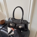 Dettaglio della borsa a bauletto nera con fibbie in metallo argento e doppie tasche frontali - Nero