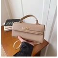 Détail de la texture cuir beige et du fermoir rotatif doré rectangulaire sur le sac à main - Kaki