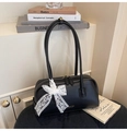 Detailed view of black Boston handbag featuring a lace floral bow and gold hardware accents - Black