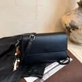 Détail d'un sac en cuir grainé noir avec bandoulière réglable et pendentif en perles - Avec Pendentif / Noir