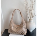 Detail der beigen Hobo-Tasche mit silbernen Metallnieten auf glatter Kunstlederfläche - Khaki
