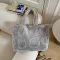 Detail of light grey plush tote bag with circular embossed patterns on a soft sofa - Light Gray
