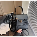 Détail du sac bandoulière en cuir noir avec boucles dorées et lanières décoratives - Noir