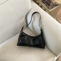 Macro detail of black glossy leather stitching and silver hardware on a shoulder bag - Black