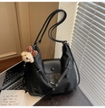 Detail of black leather crescent bag with metal buckles and cute plush bear charm - Black with Pendant