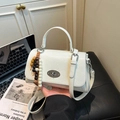 White textured leather small handbag with oval metal turn-lock and wood bead charm - White