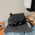 Close-up of black retro pleated bag with gold ring hardware and fashion embossed logo - Black