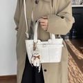 Elegante bolso bombonera blanco con textura de cuero, oso de peluche y correa ajustable - Blanco Roto
