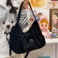 Borsa tote a tracolla nera minimalista con pieghe, tracolla regolabile e logo ovale - Nero con ciondolo