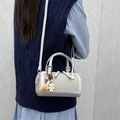 Borsa Boston in tela grigio chiaro con finiture in pelle e ciondolo a orsetto su modella - Grigio