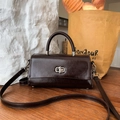 Dunkelkaffeebraune Lackleder Handtasche mit Silberverschluss in einer Lifestyle Szene - Kastanienkaffee