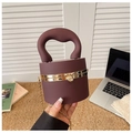 Detail of burgundy acrylic clutch bag featuring sleek handle and gold chain strap - Matte Coffee