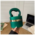 Detail of dark green cylindrical acrylic clutch with gold hardware and top handle - Matte Green