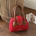Red canvas crossbody bag with brown leather handles and silver metallic logo - Red