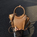 Retro brown bucket bag with round metal handle and heart pendant on dark asphalt background - Brown