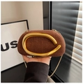Detailed view of brown woven texture and gold circular handle on elegant evening clutch - Brown
