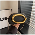 Detail of black textured evening bag featuring a gold metal handle and slim chain strap - Black