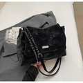 Gros plan du sac fourre-tout noir texturé avec chaîne argentée sur un blazer - Noir