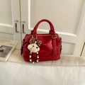 Detail view of red faux leather Boston bag featuring a plush dog charm and metal zipper - Red (With Pendant)